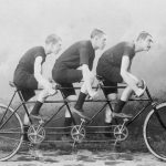 image if triple tandem being rode by 3 men, image black and white