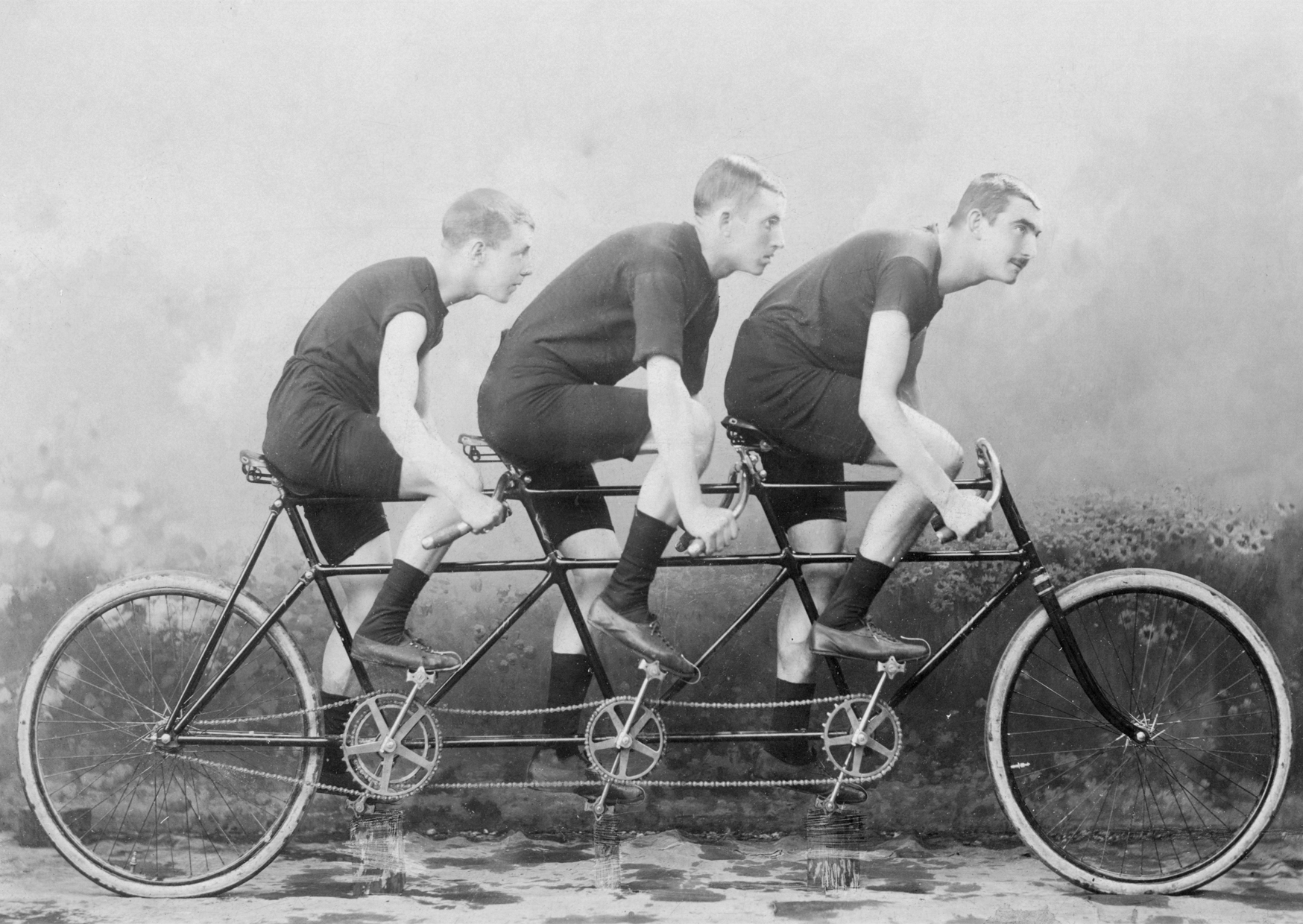 image if triple tandem being rode by 3 men, image black and white