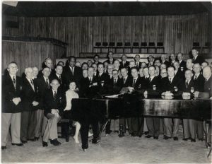 ACVMS 1996.325 Black and white photograph of Cwmbach Male Choir with Paul Robeson. Photographer Ron Bevan.